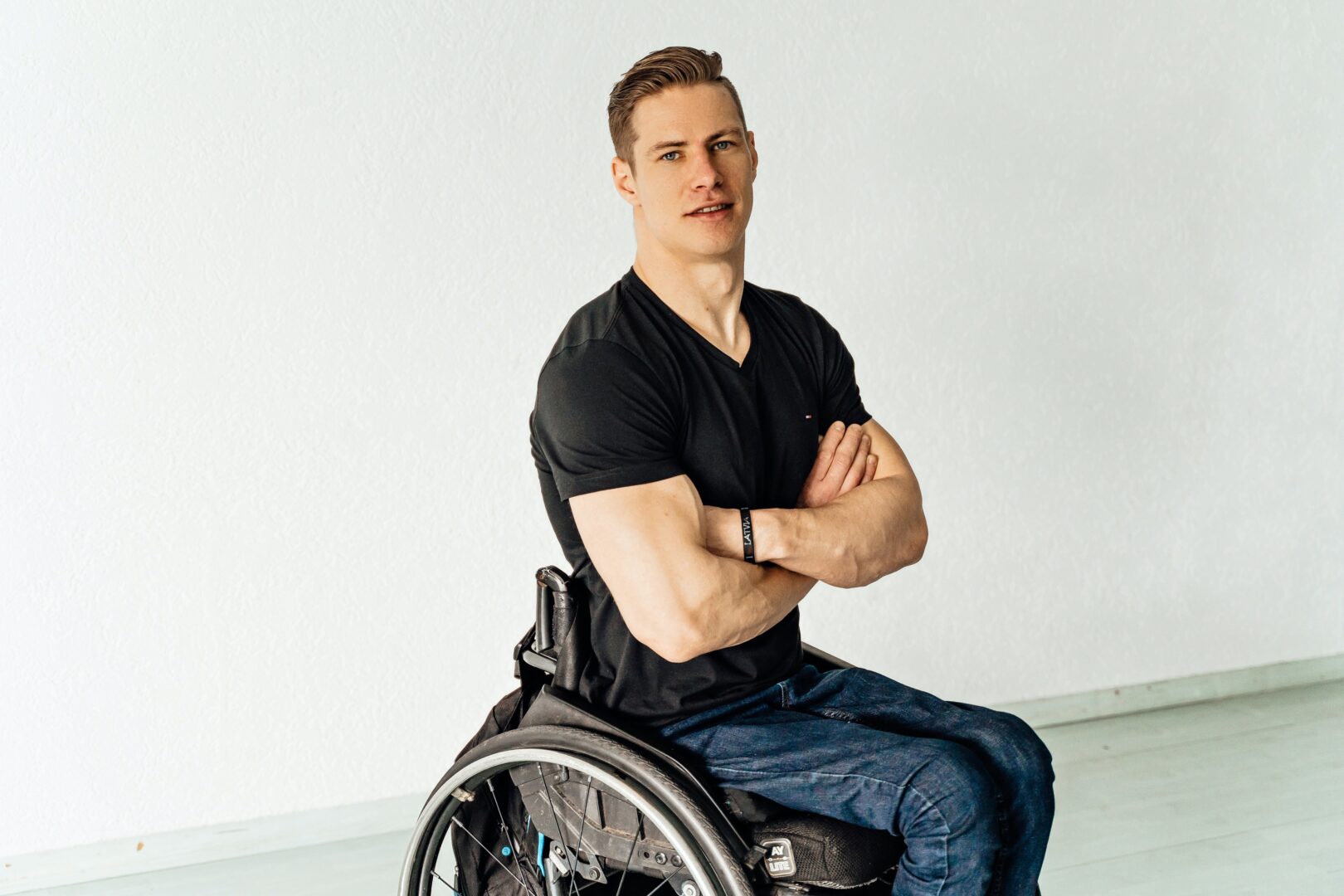 A young man with arms crossed in wheelchair
