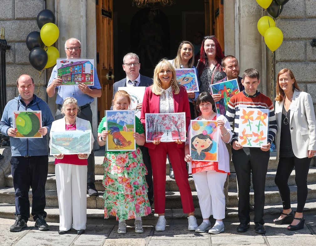 Photo of Connecting Artists artists holding their artwork with broadcaster Miriam O'Callaghan.