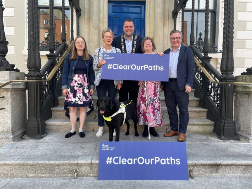 People standing on steps with Lord Mayor of Dublin holding two #ClearOurPaths signs